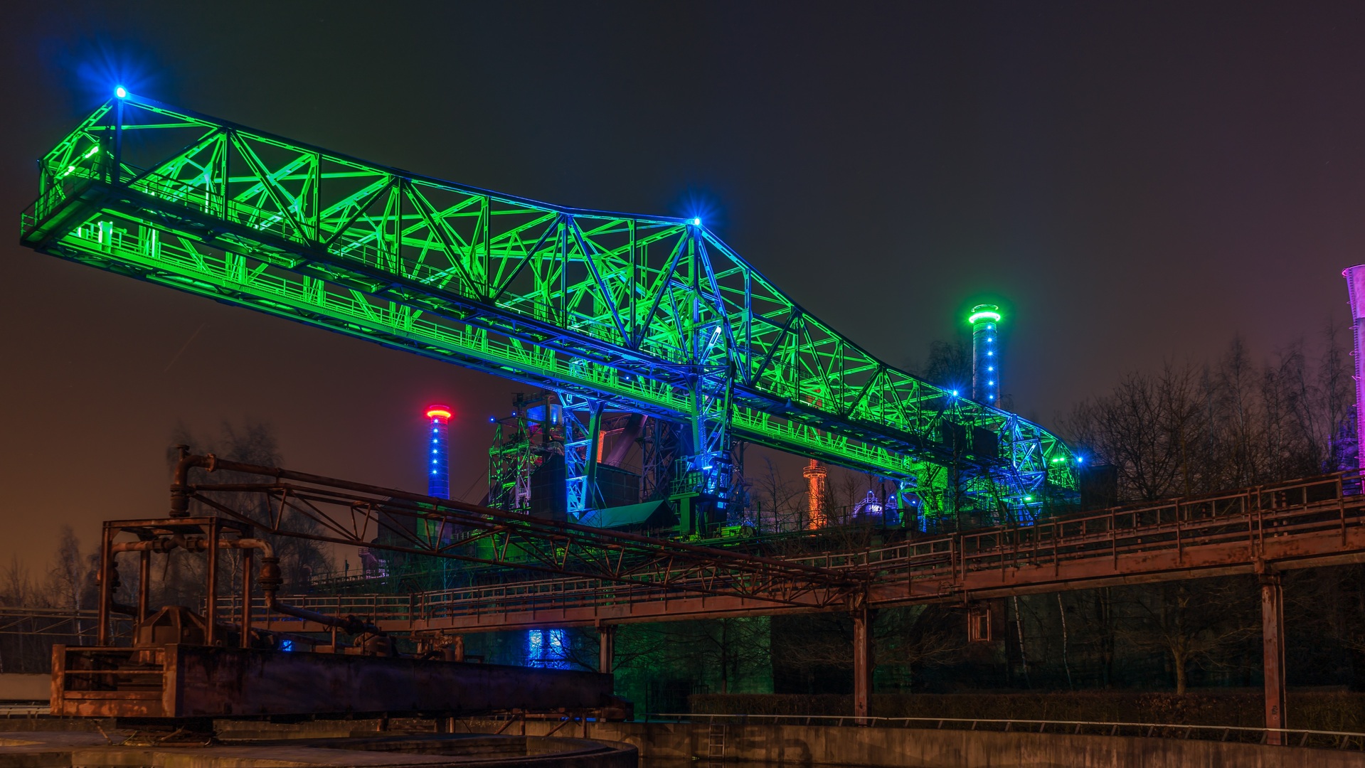 Landschaftspark Duisburg-Nord bei Nacht mit farbig beleuchteter Industriekulisse